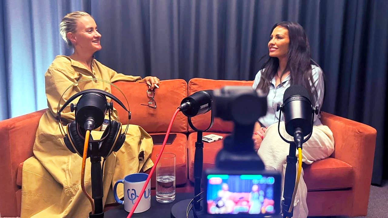 Behind the scenes in The Dokkcast studio: two people chatting on a sofa, with microphones and a camera recording the conversation